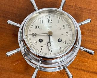 SALEM SHIP’S BELL CLOCK | Yacht wheel form ship’s bell clock in a chrome case with hinged bezel and glass cover, having an 8-day mechanical movement with ship's bell strike [not tested], signed on the face and with Arabic numeral markers
Dimensions: d. 2.5 x dia. 7 in
