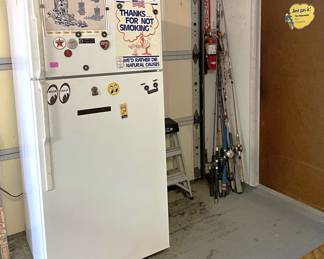 A few fishing poles are in the garage, as well as this refrigerator.