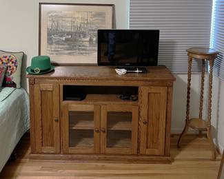 This piece could have been originally an entertainment cabinet, but you can use it in a number of different ways. Don't forget the tall plant stand in the corner, or the video monitor on top.