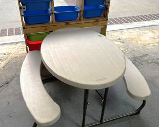 This is a child-sized picnic table. You can also see the backside of a child's storage bin system.