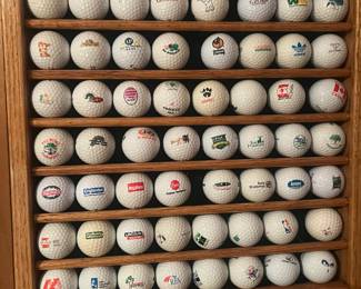 Several shadow boxes filled with collectible brand advertising golf balls