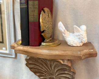 shell and marble shelf with books and vinage brass sand dollar book ends