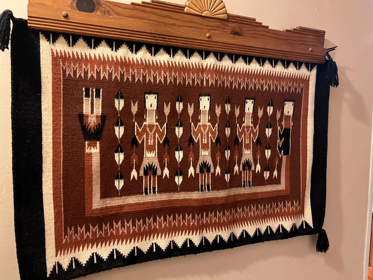 Navajo Yei figure rug surrounded by a guardian figure