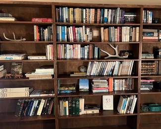 Book shelves and books including Tony Hillerman novels and vintage novels by other authors along with non-fiction, and cook books