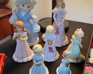 vintage KPM porcelain figurines of a girl with a goose and a collection of Enesco "Growing Up Birthday Girls" figurines,