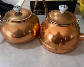 vintage copper tea kettles with blue and white ceramic handles.