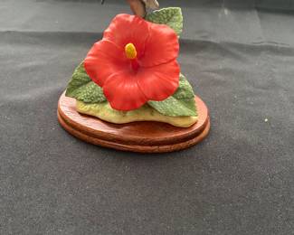 hummingbird figurine with a red hibiscus flower