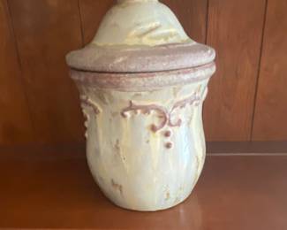 a hand-painted, lidded ceramic canister or jar with an embossed design.