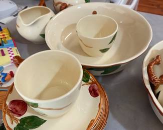 set of Franciscan Apple pattern dinnerware.
The pattern was first introduced in 1940 and features hand-painted red apples, green leaves, and brown branches on a creamy off-white earthenware background.