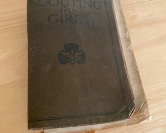 vintage edition of the "Scouting for Girls" official handbook for the Girl Scouts. It served as the primary manual for young girls in the organization, covering various skills and values.