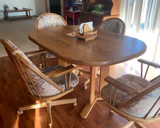 Mid - Century Dining Set with a Bow-end tabletop and four caster, swivel and tilt chairs