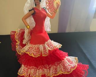 vintage Marin Chiclana Spanish flamenco dancer doll. The doll is dressed in a traditional red flamenco costume with white and gold lace ruffles, a lace headpiece (mantilla), and a fan.