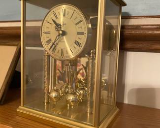 Elgin quartz anniversary clock in a gold-toned brass and glass case.