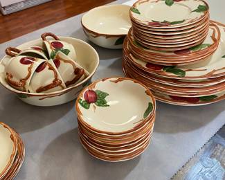set of Franciscan Apple pattern dinnerware.
The pattern was first introduced in 1940 and features hand-painted red apples, green leaves, and brown branches on a creamy off-white earthenware background.