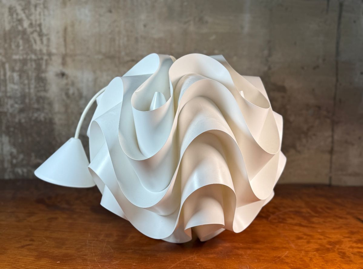 This lot features a Le Klint Model 172 Sinus Pendant light in white PVC, designed by Poul Christiansen in 1971. A beautiful work of art, measures 15” H. The designer and architect Poul Christiansen was born in 1947, he graduated in Det Kgl. School of Architecture of the Danish Academy of Fine Arts. In 1987, he founded the design company Komplot Design with Boris Berlin. He is known at the Danish company Le Klint for his Sinus suspension collection.