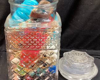 ASSORTED COSTUME JEWELRY IN A LIDDED GLASS JAR