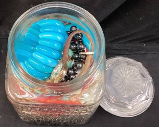 ASSORTED COSTUME JEWELRY IN A LIDDED GLASS JAR