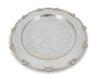 38
A Mexican sterling silver tray signed by ambassadors
1973
Marked to underside: Sterling 925 / [flag cipher] / Camusso / Made in Peru; further marked to applied sticker: Camusso Plata / 925/1000 / Sterling / Ind Peruana; inscribed: El Cuerpo Diplomatico Acreditado Ante el Gobierno de Chile al Excmo. Sr. Nathaniel Davis / Embajador de los Estados Unidos de America y Sra. / Santiago, Octubre 1973
Engraved with signatures of various ambassadors to Latin America, with opposed handles and shell accents to rim
18" Dia.
40.1 oz. troy approximately
Estimate: $800 - $1,200