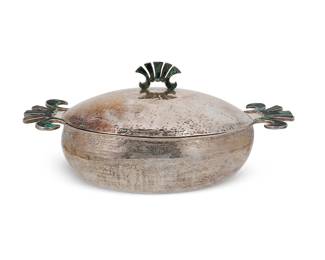 117
A Los Castillo silver-plated lidded tureen
Mid-20th century; Taxco, Mexico
Marked to underside: Los Castillo Taxco / Plateado Hecho en Mexico / TA-01
With green hardstone-inlaid opposed handles and lid finial
7.625" H x 17.375" W x 8.5" D
Estimate: $600 - $800