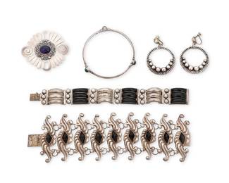 202
A group of Mexican silver jewelry including Carmen Beckmann
Mid/late 20th century
Five works:

Carmen Beckmann (b. 20th century)
A sterling silver stone-set bangle bracelet, late 20th century, San Miguel de Allende
Stamped: Beckmann / Sterling / Mexico
A narrow band with three set green stone cabochons and silver wire overlay accents
7.875" inner C x 0.25" H

A group of Mexican silver jewelry
Each variously marked: Sterling / Mexico / Silver / RHC / Taxco / Hecho en Mexico DF / MFR / 900
Four works comprising an elaborate silver swirl repoussé link bracelet with set pyramidal obsidian, and a set onyx and silver link bracelet, as well as a silver brooch with set blue glass cabochon, and a pair of round sterling earrings with silver ball accents
5 pieces
Bracelets: 7.5" L x 2.375" H & 7.75" L x 0.875" H; Brooch: 2.125" H x 2.5" W; Earrings: 2" H x 1.5" Dia.

6 pieces total
169.8 grams gross
Estimate: $300 - $500