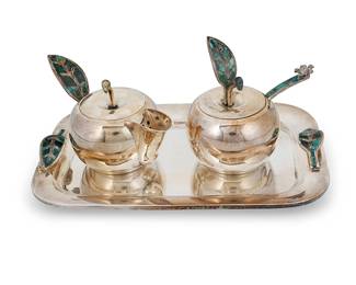 118
A Los Castillo silver-plated cream and sugar set
Mid-20th century; Taxco, Mexico
Each marked to underside: Los Castillo Taxco / Mexico / Plateado / 401
Each with green hardstone inlaid elements, comprising an apple-form lidded creamer and lidded sugar with spoon, all set on a rectangular tray with leaf-form handles
4 pieces
Creamer: 3.625" H x 6.375" W x 3.375" D; Tray: 1" H x 10.5" W x 6.75" D
Estimate: $200 - $400