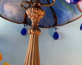 blue Tiffany-style stained glass table lamp with a scalloped shade and hanging blue glass accents