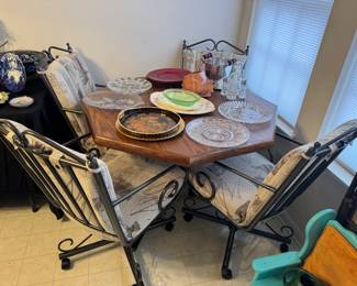 Octagon Wood dining table with 4 rolling metal chairs and cushions. Has one insert that can be added 
