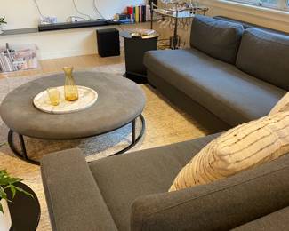 $680.  Nicholas round coffee ottoman. Bronze finish, carbon color brushed Belgian flax linen.  Originally $2643.  It is 46 inches  in diameter by 12 inches high.   No longer available in this size.  Accessories shown are only available during in-person shopping hours Friday and Saturday.