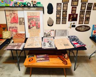 A collection of newsprint from the Omaha World-Herald. Military memorabilia, such as a U.S. Fighting Pilots book and a set of aviator wings. A leather holster, and a collection vintage 'Life' magazine.