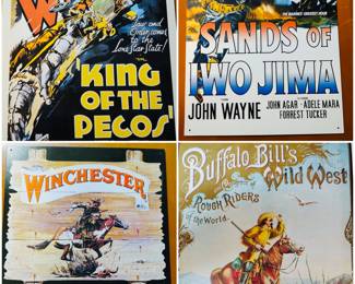 A collection of reproduction tin signs featuring vintage movie and advertising artwork, such as John Wayne films like King of the Pecos and Sands of Iwo Jima, also historical advertising for Winchester Firearms and Buffalo Bill's Wild West show.