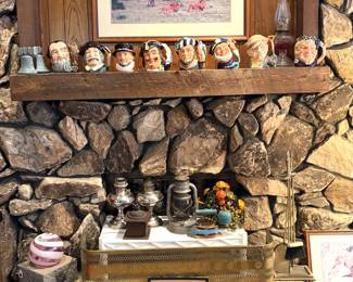 A collection of vintage Royal Doulton Toby mugs, vintage oil lamps, a framed piece of sheet music titled "WHEN MY DREAMS COME TRUE" and a vintage advertisement featuring a child drinking orange juice.