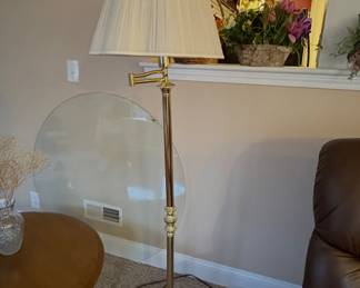Swinging floor lamp with a brushed antique brass finish
