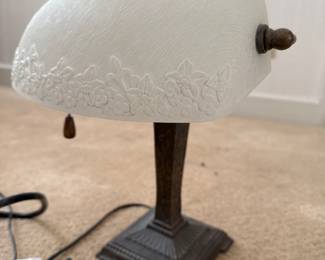 Vintage metal lamp with detailed glass shade.