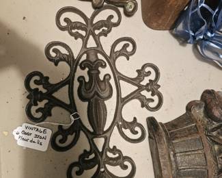 Ornate cast iron decorative wall accent with fleur-de-lis.
