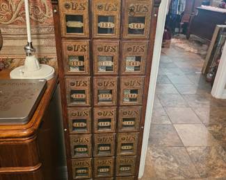Antique oak and brass U.S. Post Office box cabinet with numbered compartments.