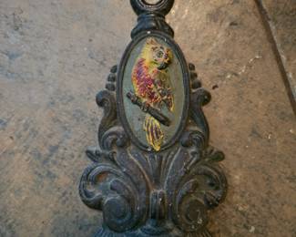 Antique cast iron doorstop with a painted parrot motif.