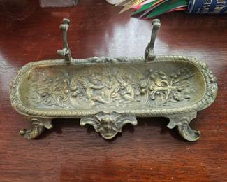 Ornate bronze decorative tray with cherubs and floral motifs.