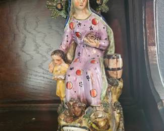 A 19th-century Staffordshire earthenware figure titled 'The Widow' with a child.