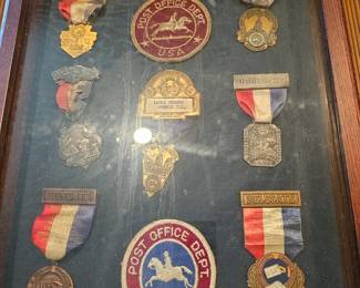Framed collection of United States Postal Service and Railway Mail Service badges.