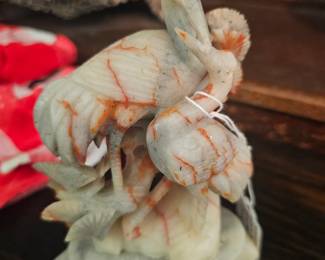 A carved soapstone sculpture of birds and flowers on an openwork base.