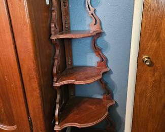 A carved wooden multi-shelf corner etagere with Victorian-era styling.