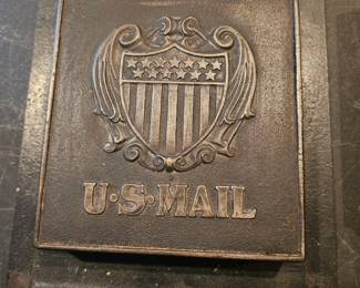 Antique cast iron U.S. Mail slot with shield emblem.