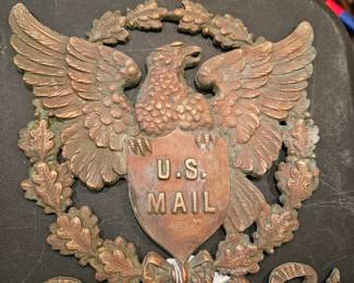 Cast metal U.S. Mail eagle emblem with oak leaf wreath.