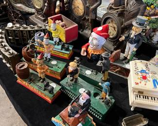 Eclectic collection of vintage collectibles and novelty items. Includes character figurines, animated display pieces, and decorative clocks with sculptural forms. A colorful assortment of mechanical-style figures and nostalgic décor, ideal for collectors, display, or resale.