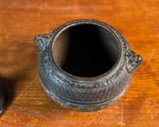 This lot features an Asian Koro, or incense burner, featuring a foo dog finial that measures, 7” H x 5” W x 5” D.

