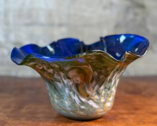 This lot features a stunning art glass vase by listed artist, Mark Russell. Signed underneath as shown in photos and measures, 7” H x 11” W x 11” D.

