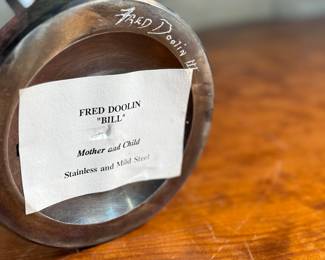 “Mother and Child”, a steel sculpture by listed artist, Fred Doolin. Signed underneath as shown in photos and measures, 13” H x 6” W x 6” D.

