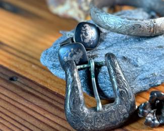 This lot features a curated collection of antique sterling silver items including a bracelet, Taxco earrings, Siam cufflinks, & a belt buckle. Total approx. weight of 63.44 grams.

