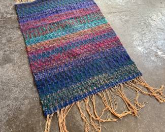 This lot features a beautiful handwoven, multi-color rug or wall art that measures, 35” H x 24.5” W.

