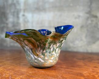 This lot features a stunning art glass vase by listed artist, Mark Russell. Signed underneath as shown in photos and measures, 7” H x 11” W x 11” D.

